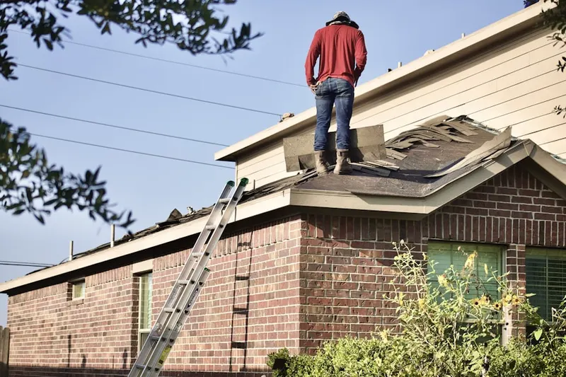 Professional roofer working on a residential roof in Thaxton
